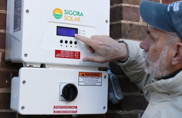 Dave Pruett checkes the inverter panel installed by Sigora Solar.
