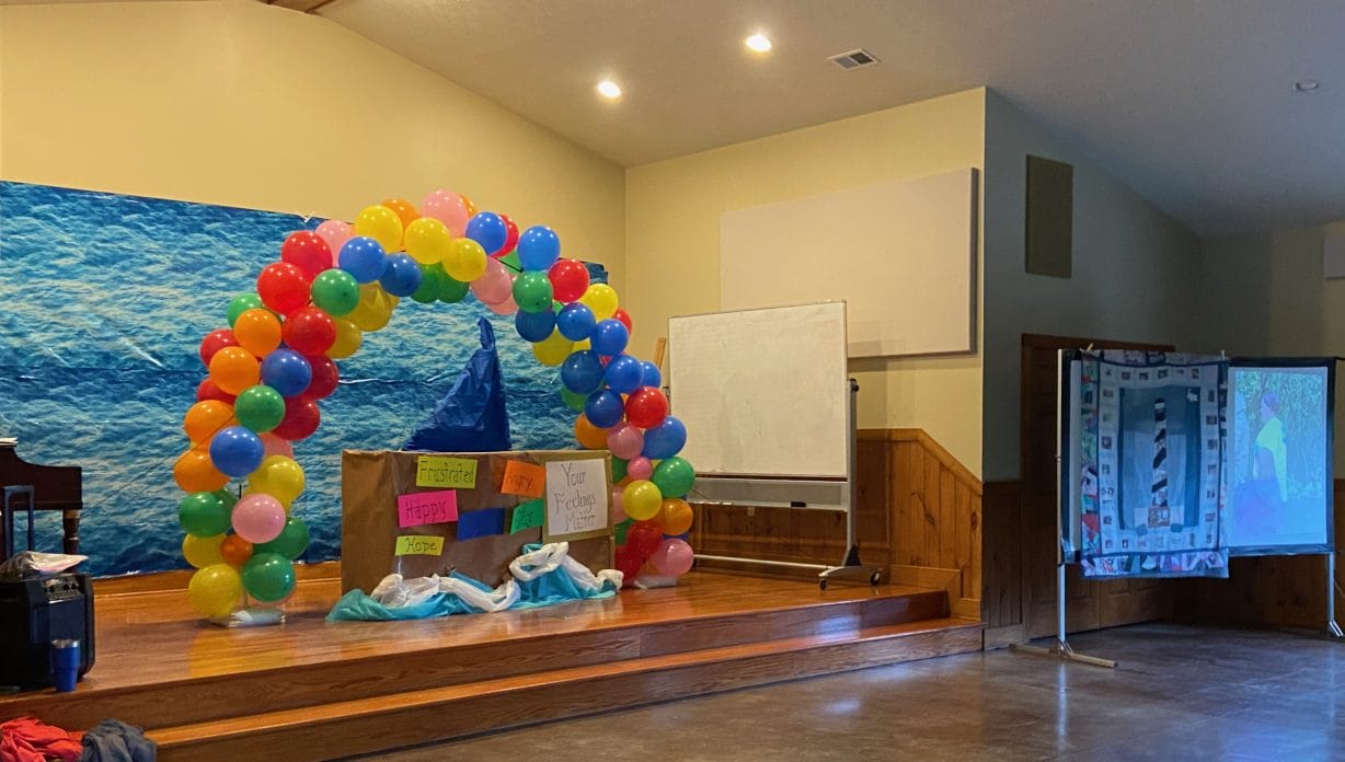 A stage with balloons and signs with different words for feelings, like anger, joy and frustration.