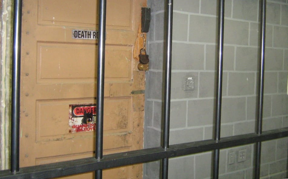 A view of jail bars and a prison door