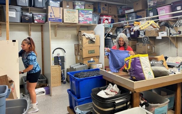 Two women working in a cluttered store room
