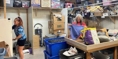 Two women working in a cluttered store room