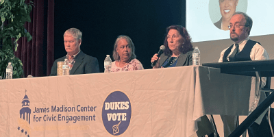 Four people with microphones sit at a table