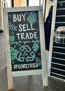 A sign saying "Buy Sell Trade" and "Recycle Your Style" and "#GentlyUsed"