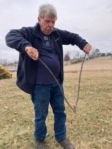 A man holding a triangle shaped branch