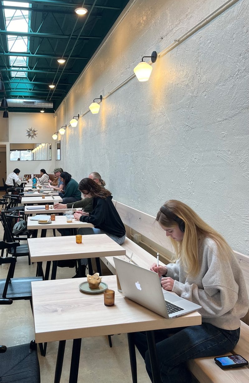 People write and type of laptops on wooden tables.