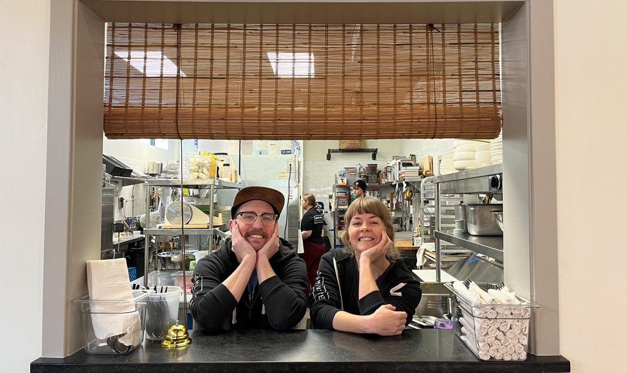 Two people smiling and leaning on their elbows