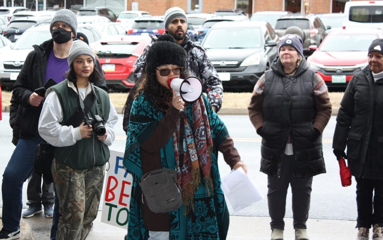 A woman with a megaphone addresses a crowd