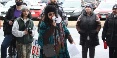 A woman with a megaphone addresses a crowd