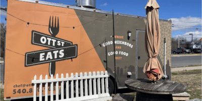 A food truck trailer next to a picnic table