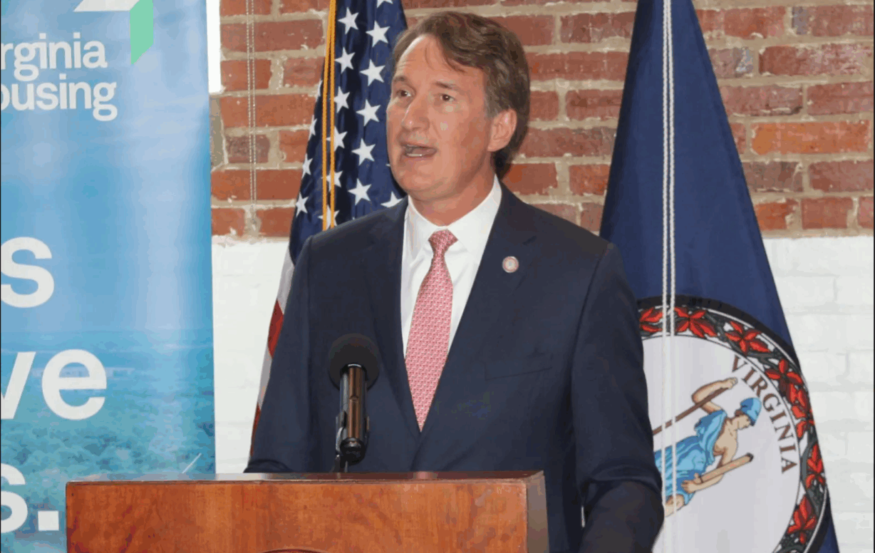 A man in a suit talks at a podium