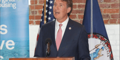 A man in a suit talks at a podium